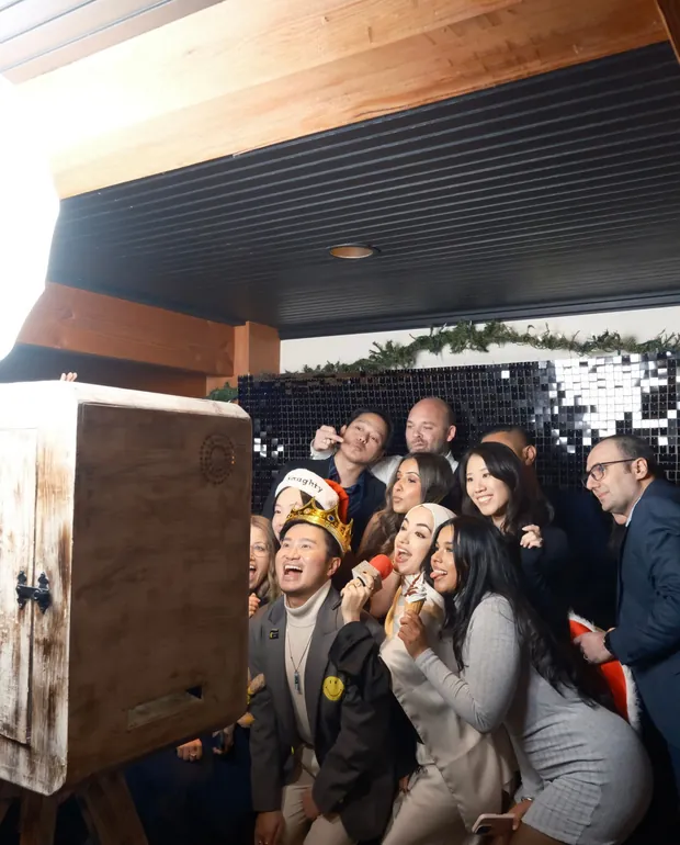 A group of colleagues posing in front of the photo booth at a corporate event