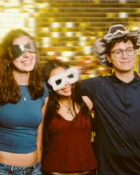 Four children and a teenager posing in front of the photo booth for a children party.