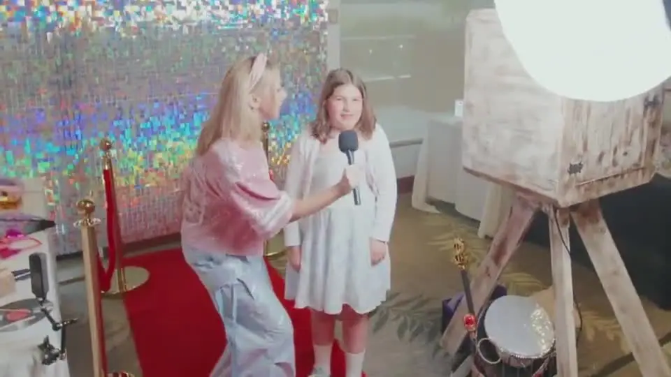 Red-carpet interview with a young guest next to the photo booth