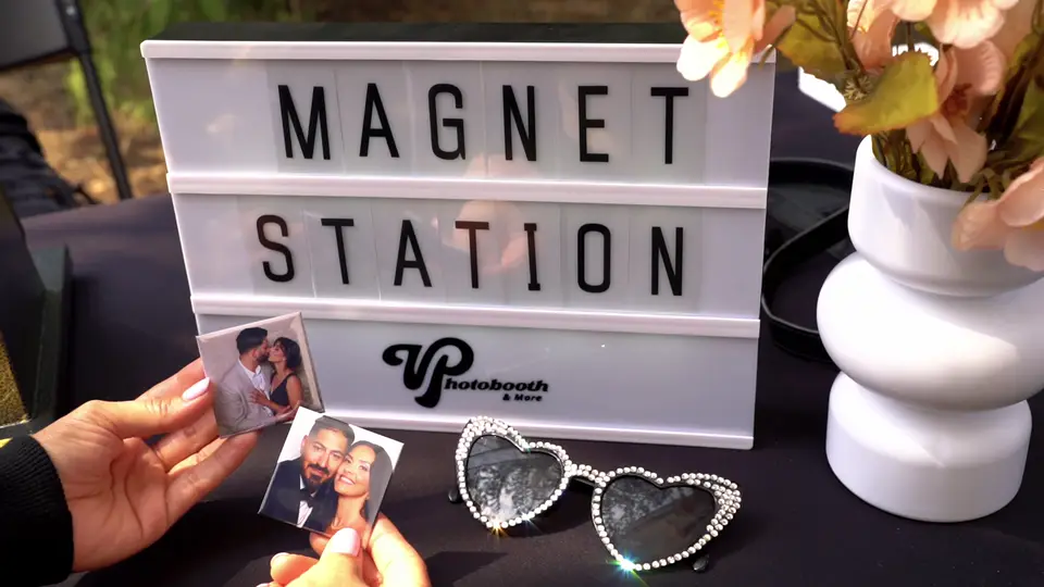 Magnet station: a photo booth print pressed into a fridge magnet next to the lightbox sign