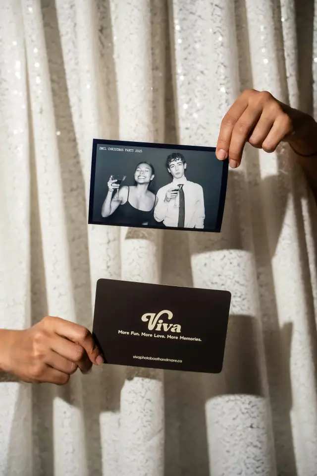 Hands holding a Viva photo print in front of a silver backdrop