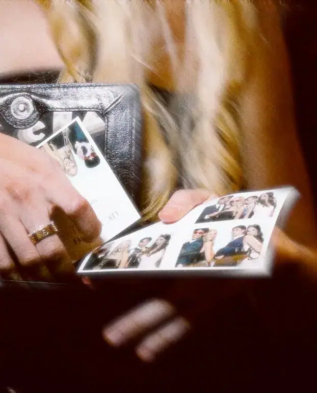 Hands holding fresh photo booth print strips