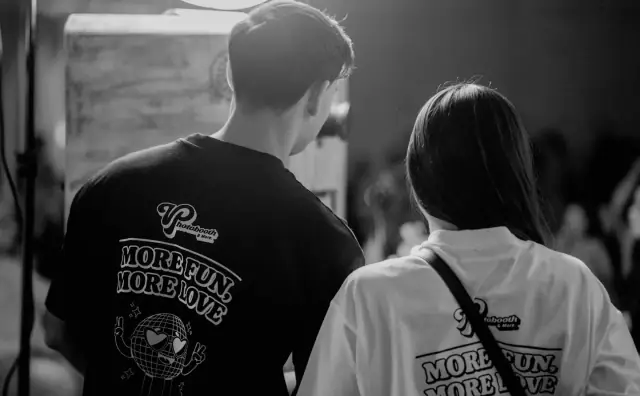 Viva hosts in branded shirts working the booth, black and white