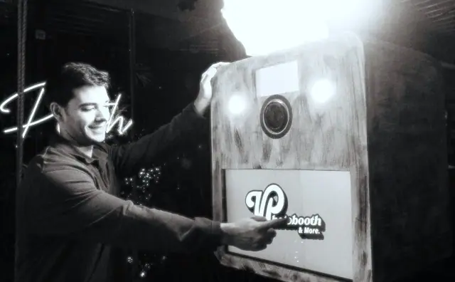 Host next to the wooden Viva open-air booth, black and white